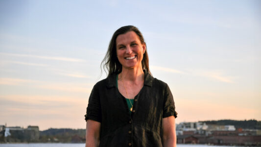 Kvinna i t-shirt i kvällssol.