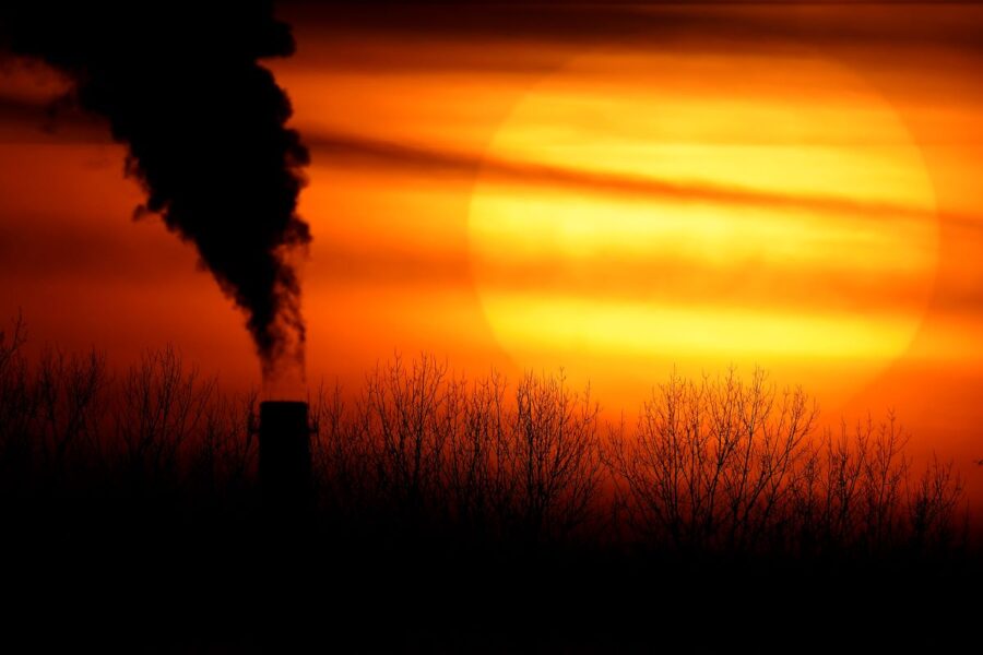 FILE - In this Monday, Feb. 1, 2021 file photo, emissions from a coal-fired power plant are silhouetted against the setting sun in Independence, Mo. Dozens of European lawmakers, business executives and union leader called Tuesday for the United States to cut its greenhouse gas emissions by 50% in the coming decade compared with 2005 levels. (AP Photo/Charlie Riedel) MAS104