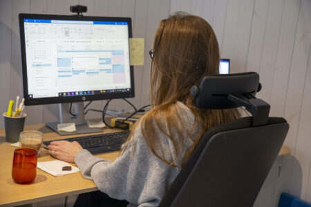 Kvinna sitter framför dator.