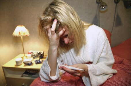 En kvinna håller i en termometer.