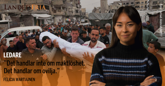 Tre personer bär på ett lik insvept i vit plast. Skribenten i förgrunden.