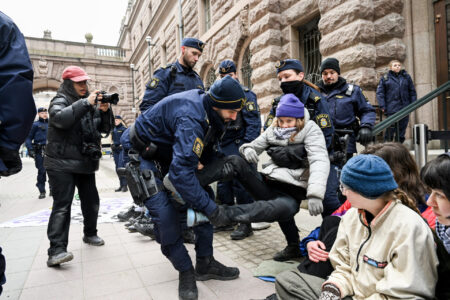 Greta Thunberg lyfts av poliser.