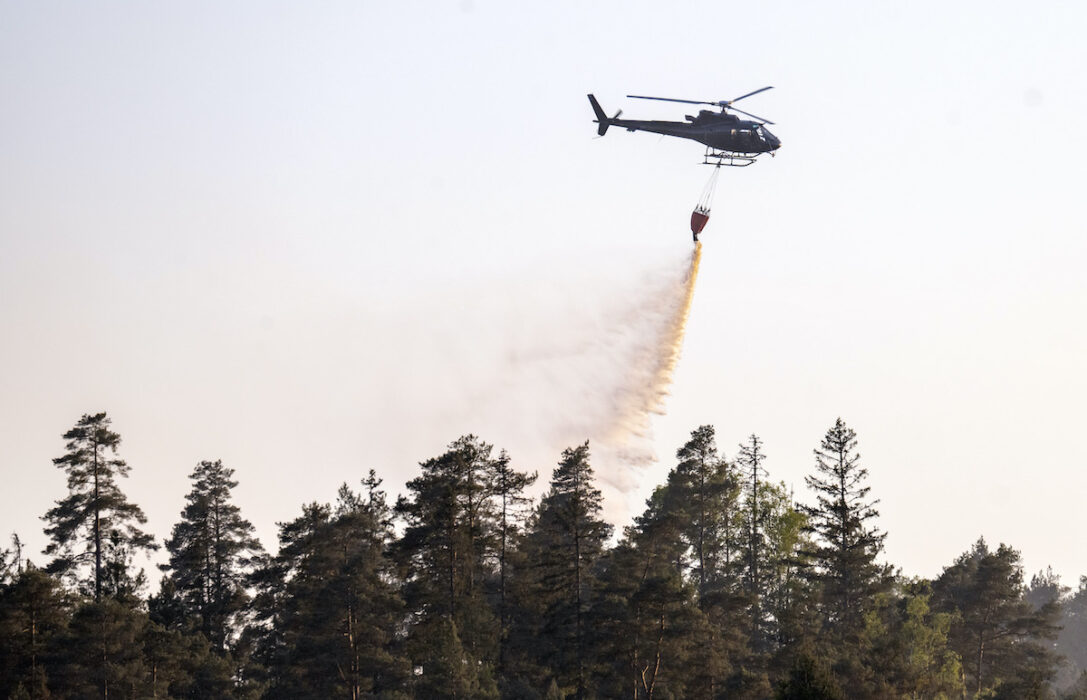 Helikopter vattenbombar skogen kring en torvtäkt i halländska Kråkeryd utanför Hyltebruk under en brand, 16 maj 2025.
