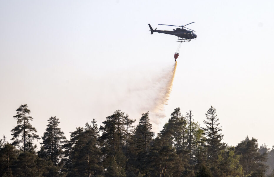 Helikopter vattenbombar skogen kring en torvtäkt i halländska Kråkeryd utanför Hyltebruk under en brand, 16 maj 2025.
