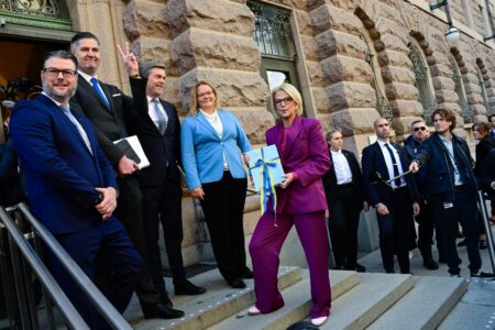 Finansminister Elisabeth Svantesson i lila kostym håller i budgetproposition.
