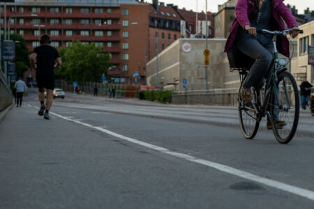Cykel i förgrund, joggare i bakgrund.