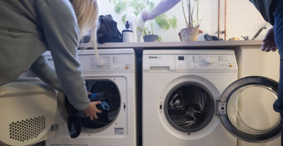 person stoppar in tvätt i tvättmaskin