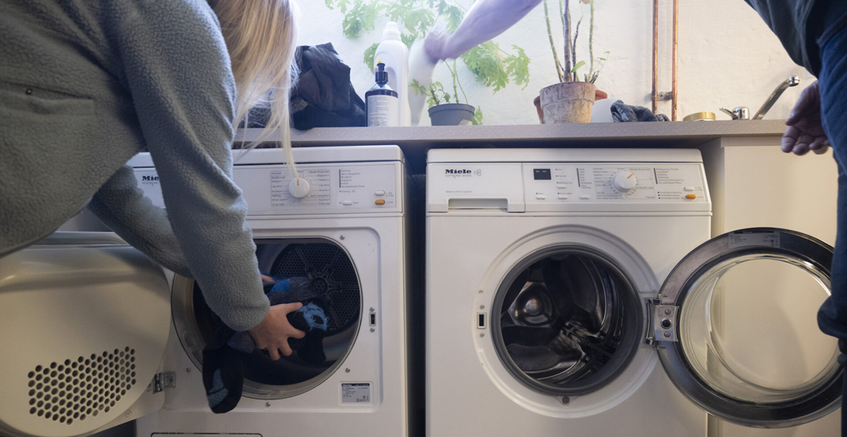 person stoppar in tvätt i tvättmaskin