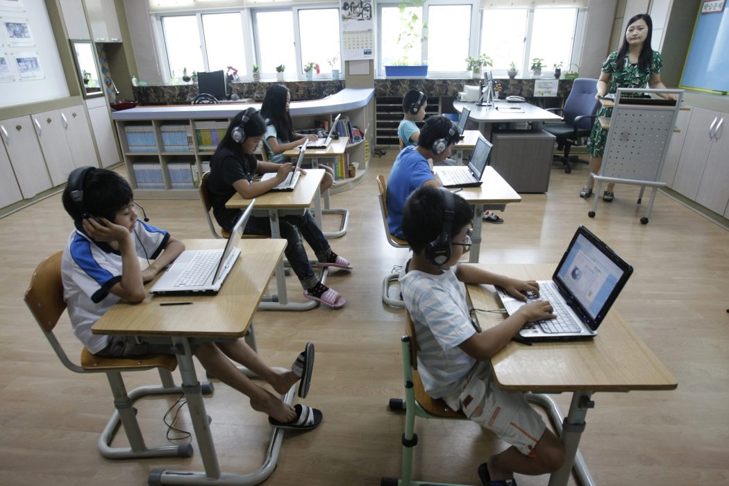 In this Friday, July 15, 2011 photo, teacher Yeon Eun-jung, right top, gives a lesson to students, using tablet PCs at Sosu Elementary School in Gwesan, South Korea. The country is taking a $2 billion gamble that its students are ready to ditch paper textbooks in favor of tablet PCs as part of a vast digital scholastic network. (AP Photo/Ahn Young-joon)