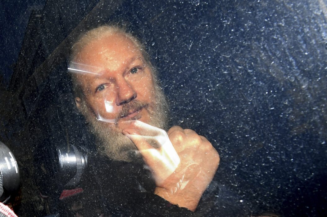 Julian Assange gestures as he arrives at Westminster Magistrates' Court in London, after the WikiLeaks founder was arrested by officers from the Metropolitan Police and taken into custody Thursday April 11, 2019. Police in London arrested WikiLeaks founder Assange at the Ecuadorean embassy Thursday, April 11, 2019 for failing to surrender to the court in 2012, shortly after the South American nation revoked his asylum .(Victoria Jones/PA via AP)