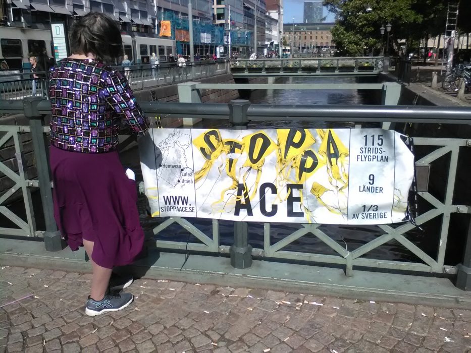 Kvinna protesterar mot den militära flygövningen Arctic Challenge.