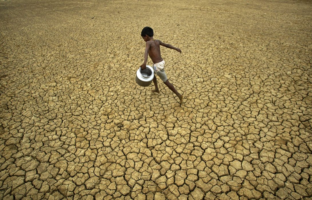 An Indian village boy runs through a parched field on World Water Day in Berhampur, Orissa state, India, Monday, March 22, 2010. Clean Water for a Healthy World is the theme for World Water Day 2010. (AP Photo/Biswaranjan Rout)