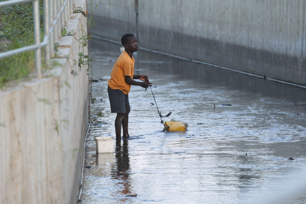 A child fetches dirty water from a channel in Beira, Mozambique,Wednesday, March, 27, 2019. Mozambiquan authorities say the first cases of cholera have been confirmed in the cyclone ravaged city of Beira, raising the stakes in an already desperate fight to help hundreds of thousands of people sheltering in increasingly squalid conditions.(AP Photo/Tsvangirayi Mukwazhi)
