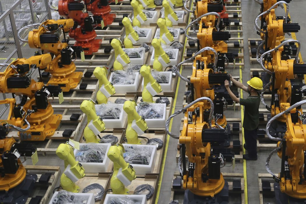 A worker checks on robot arms at a factory in Nanjing in east China's Jiangsu province, Thursday, June 6, 2019. China's Commerce Ministry will release a list of "unreliable" foreign companies in the near future, a spokesman said Thursday, without giving a specific date. The new list, announced last week, is widely seen as a response to a U.S. decision to put Huawei Technologies on a blacklist for alleged theft of intellectual property and evasion of Iran sanctions. (Chinatopix via AP)