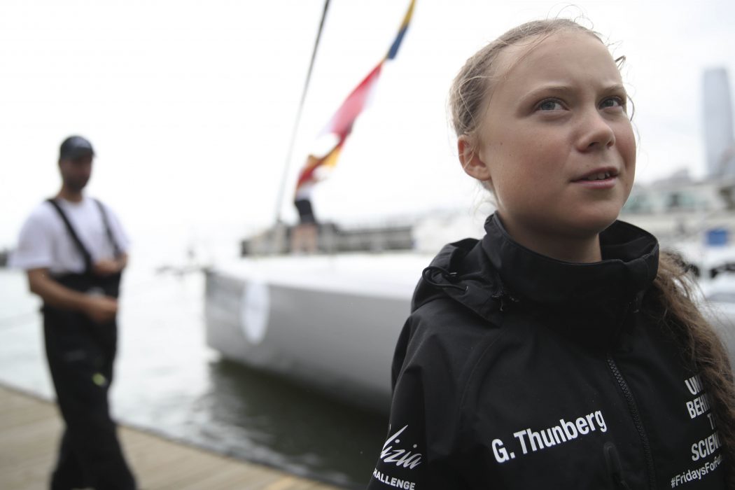 Boris Herrmann, left, the captain of the zero-emissions yacht, the Malizia II, is seen in the dock as Greta Thunberg, a 16-year-old Swedish climate activist, talks to reporters after they arrived in New York, Wednesday, Aug. 28, 2019, in New York. Thunberg is scheduled to address the United Nations Climate Action Summit on Sept. 23. (AP Photo/Mary Altaffer) NYMA103