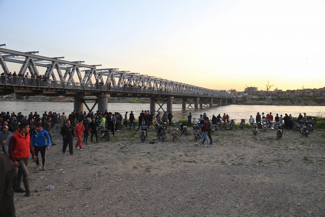 People and relatives of victims waiting on the bank of the Tigris river where the ferry sank in Mosul, Iraq, Thursday, March 21, 2019. A ferry overloaded with people celebrating the Kurdish new year sank in the Tigris River near the Iraqi city of Mosul on Thursday, killing dozens of people, mostly women and children, officials said. (AP Photo/Farid Abdulwahed)