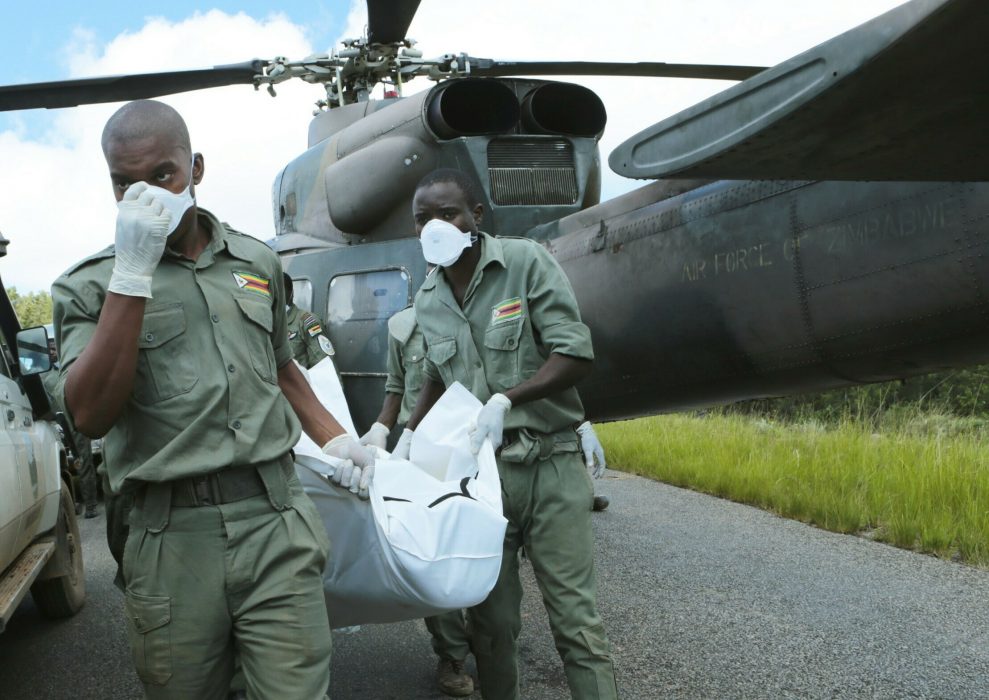 Personnel carry a body from a military helicopter in Chimanimani, about 600 km south east of Harare, Zimbabwe, Wednesday, March, 20, 2019. Zimbabwean President Emmerson Mnangagwa visited a part of Chimanimnani affected by cyclone Idai and promised assistance in the form of food and rebuilding of homes. Hundreds are dead, many more missing and thousands at risk from massive flooding in Mozambique, Malawi and Zimbabwe caused by Cyclone Idai. (AP Photo/Tsvangirayi Mukwazhi)
