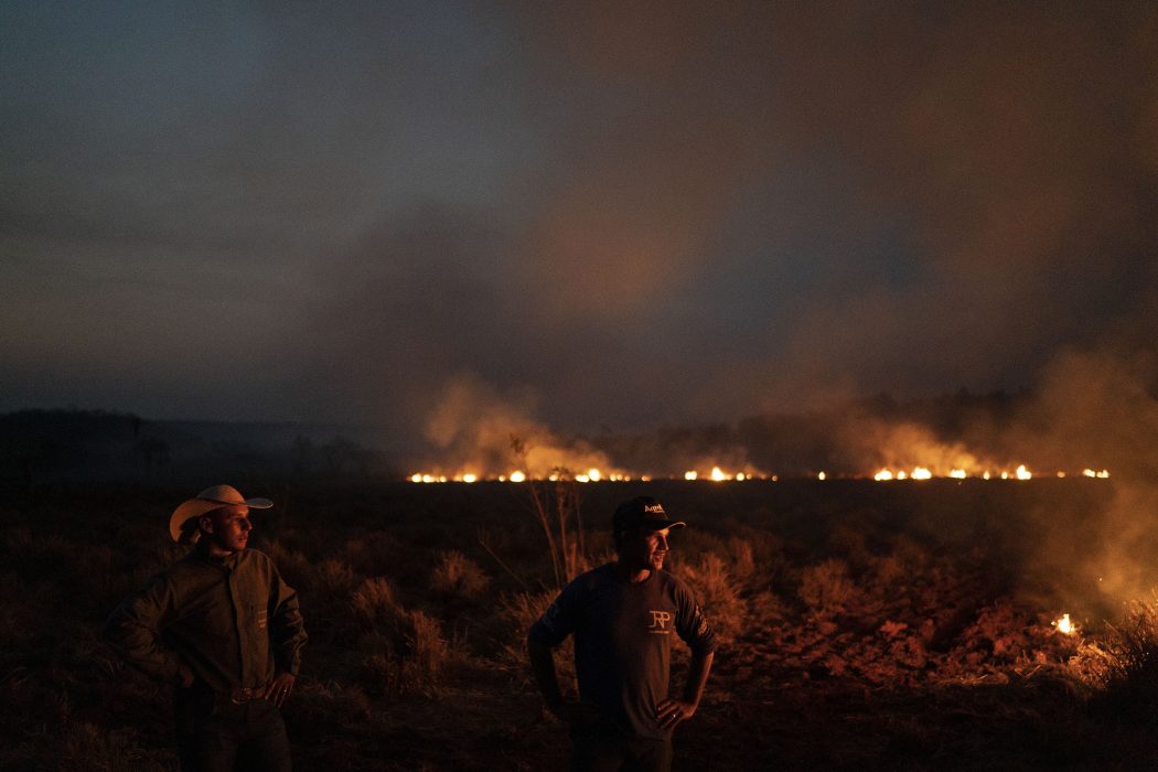 Neri dos Santos Silva, center, watches an encroaching fire threat after digging trenches to keep the flames from spreading to the farm he works on, in the Nova Santa Helena municipality, in the state of Mato Grosso, Brazil, Friday, Aug. 23, 2019. Under increasing international pressure to contain fires sweeping parts of the Amazon, Brazilian President Jair Bolsonaro on Friday authorized use of the military to battle the massive blazes. (AP Photo/Leo Correa) XSI114
