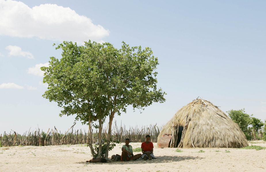 Två botswanska kvinnor söker skydd från solen i centrala Kalahari.