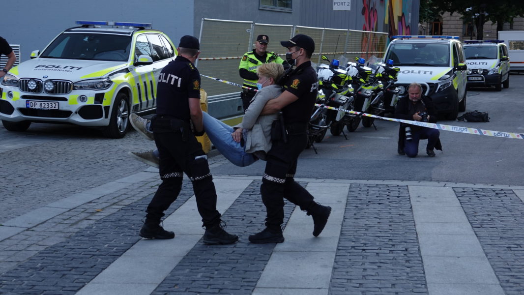 En aktivist som deltog i blockaden inne på det norska energi- och oljedepartementet bärs bort av polisen.